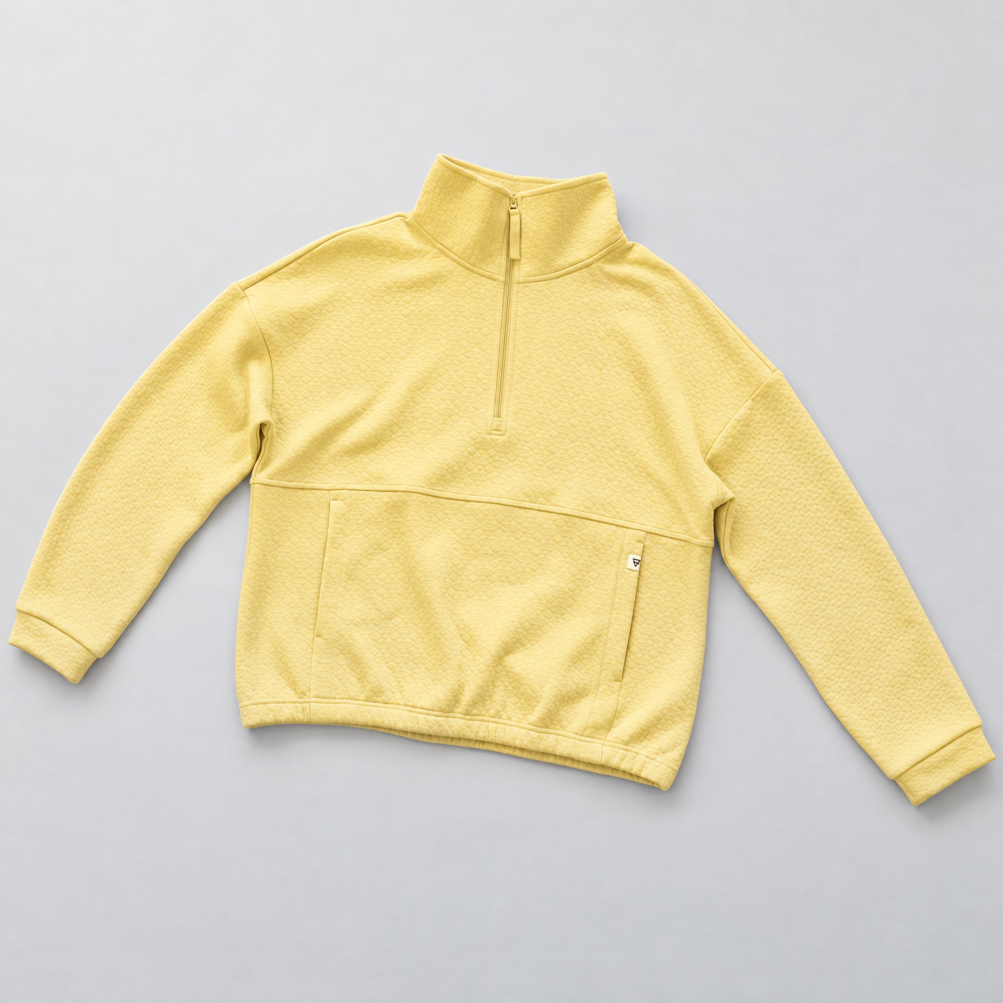 Women's LIV Outdoor Kaya quilted pullover with quarter-zip front, shown in a stylish sundress flat lay.